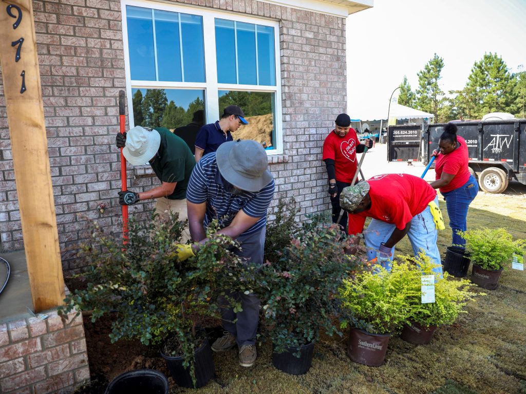 A community has come together to help with landscaping on a Habitat build site.