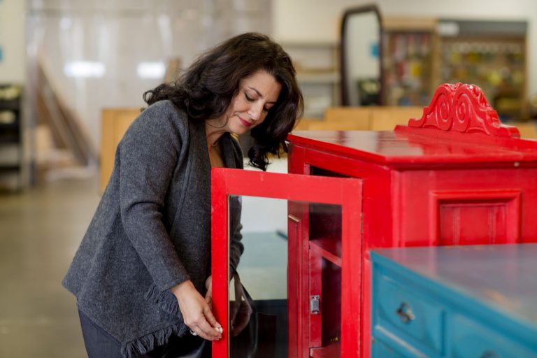 Woman looking at a red cabinet at the Habitat ReStore.